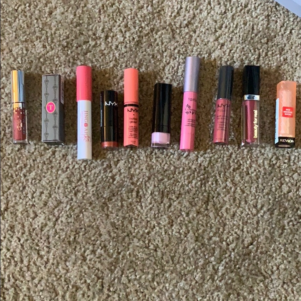 Assorted lipsticks/lipglosses. Red/pink tones.